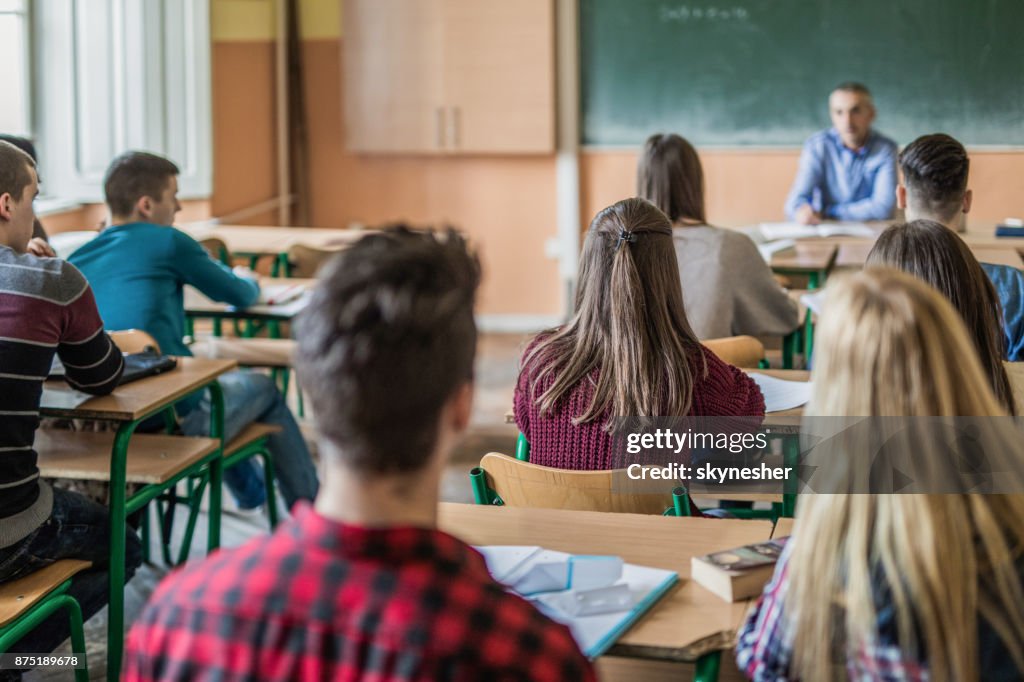 Rear view of high school students attending a class.