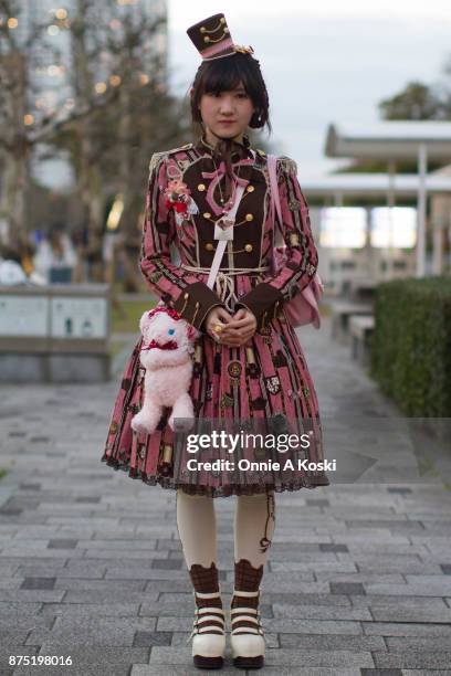 Moka-chan, wearing a cookie-themed pink and brown dress by Angelic Pretty, miniature pink and brown top hat, white leather platform Mary Janes shoes...