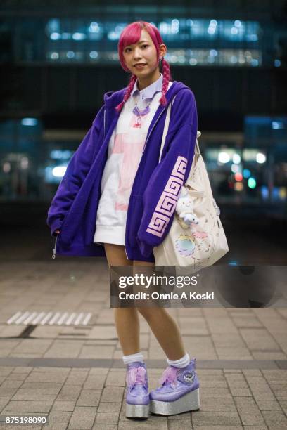 Tuxell, with purple hair, wearing a blue zip hoodie, a Ezaki besuko white and pink shirt with lavender cross collar, Yumetembo glitter platform...