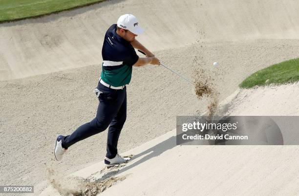 Tyrrell Hatton of England plays his third shot from an awful lie in the greenside bunker on the 18th hole during the second round of the DP World...