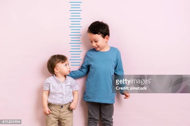 測量他的高度的孩子 - 高度表 個照片及圖片檔