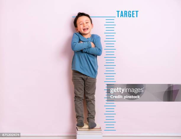 child measuring his height - height chart stock pictures, royalty-free photos & images