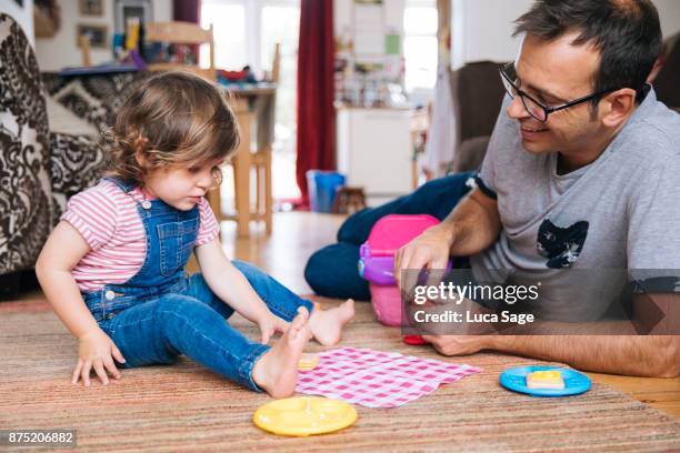 father and daughter on the floor, pretending to have a picnic. - indoor picnic stock pictures, royalty-free photos & images