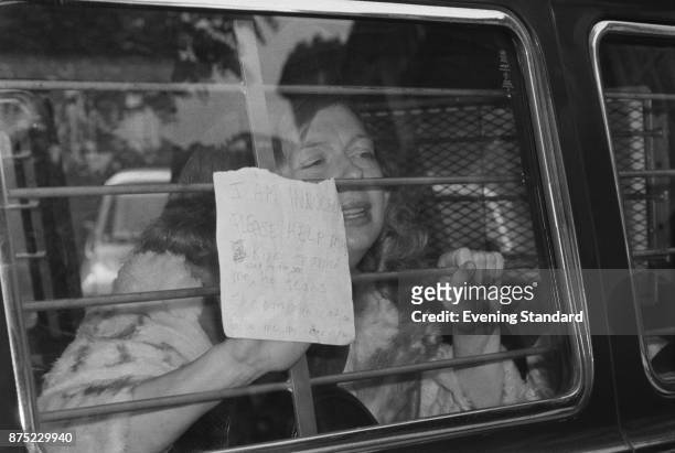 American beauty queen Joyce McKinney, holding a message against the barred window of the police van. She and Keith May are accused of kidnapping the...