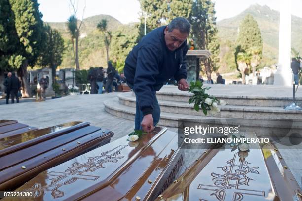 Man lays white roses on the coffins of 26 teenage migrant girls found dead in the Mediterranean in early November, before a funeral service on...