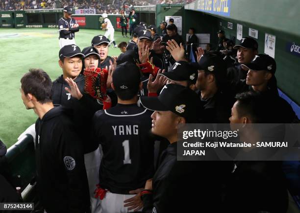 Outfielder Yang Dai-Kang of Chinese Taipei high fives with his team mates in the dugout after the bottom of fourth inning during the Eneos Asia...