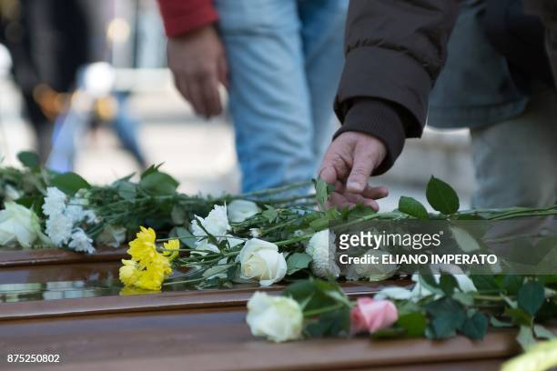 People lay flowers on the coffins of 26 teenage migrant girls found dead in the Mediterranean in early November, during the inter religious funeral...