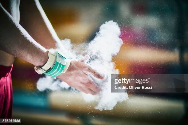 close-up of gymnast applying sport chalk on his hands - magnesium stock-fotos und bilder