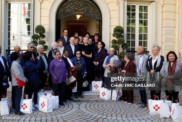 Prince Albert II of Monaco and Princess Charlene of Monaco pose with Monaco's residents during a Christmas gift-giving event at the headquarters of...