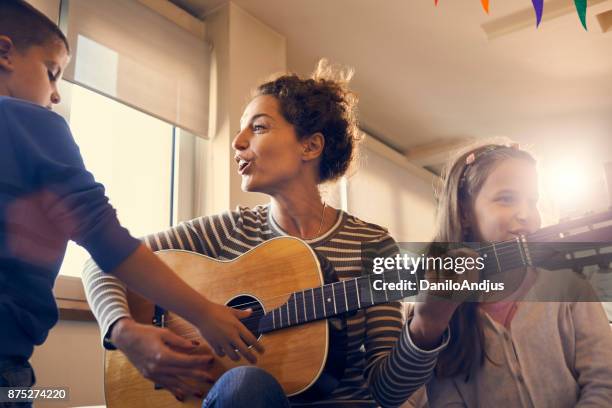 spaß haben und spielen gitarre mit kindern - vater sohn musik stock-fotos und bilder