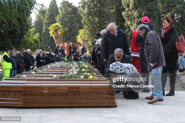 Woman kneeling in front of the coffins, during the funeral of the 28 migrant women who died in a shipwreck as they sought to reach Italy.