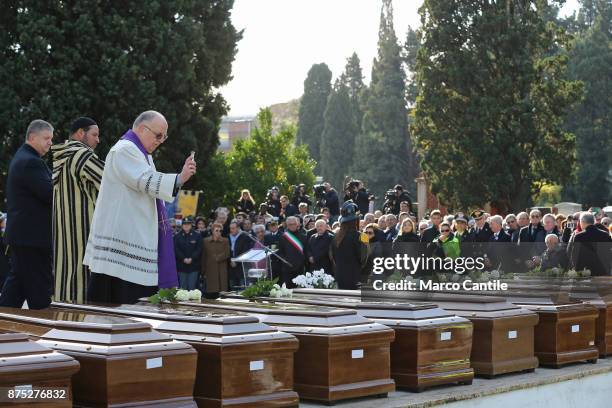 The priest, together with a Muslim representative, blesses the coffins, during the funeral of the 28 migrant women who died in a shipwreck as they...