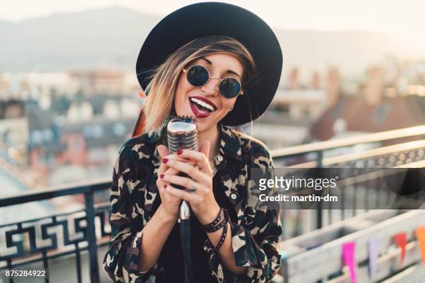 singer on the rooftop - pop musician stock pictures, royalty-free photos & images