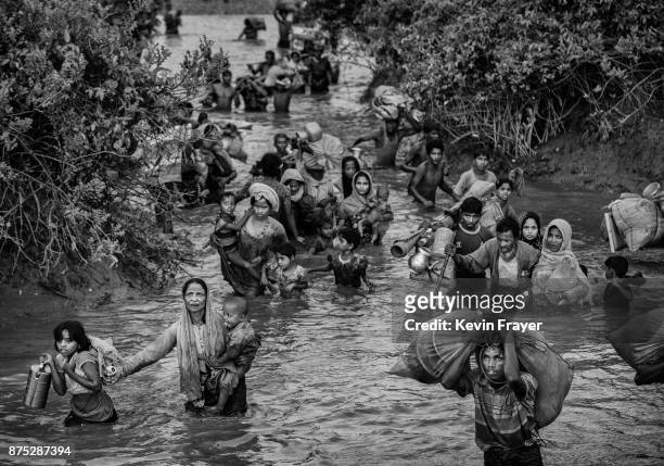 Rohingya Muslim refugees crowd a canal as they flee over the border from Myanmar into Bangladesh at the Naf River on November 1, 2017 near Anjuman...
