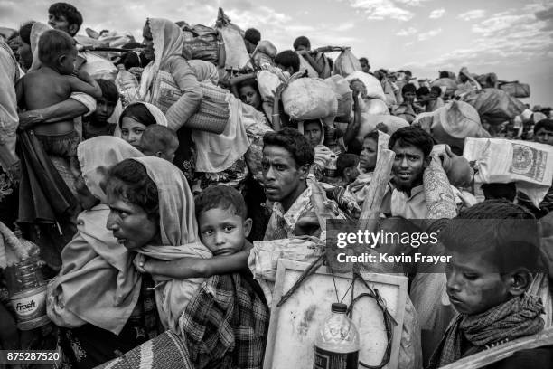 Rohingya Muslim refugees waiting to proceed to camps after crossing the border from Myanmar into Bangladesh crowd on an earthen berm close to the Naf...