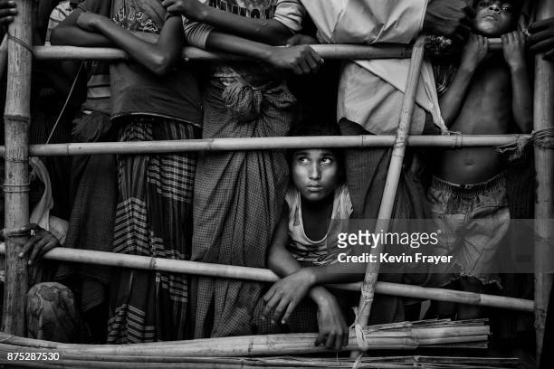 Rohingya Muslim refugee boy waits with others to receive food aid from a local NGO on October 24, 2017 at the Kutupalong refugee camp in Cox's Bazar,...