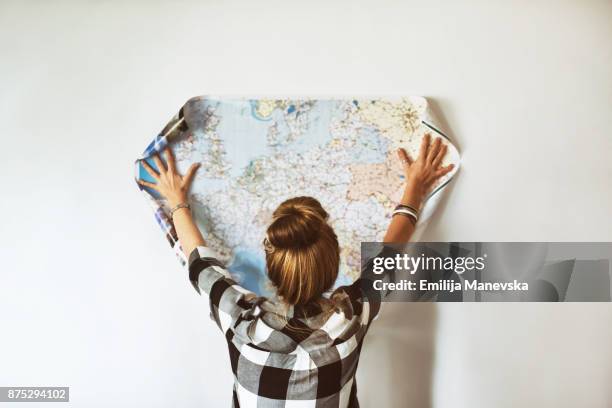 young woman looking at map - map monde photos et images de collection