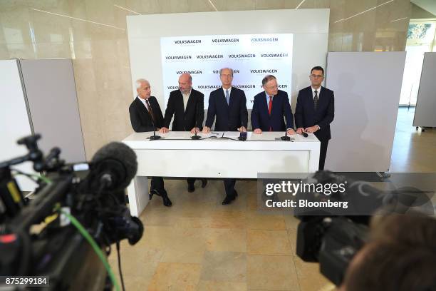 From left, Matthias Mueller, chief executive officer of Volkswagen AG, speaks as Bernd Osterloh, works council chief at Volkswagen AG, Hans Dieter...