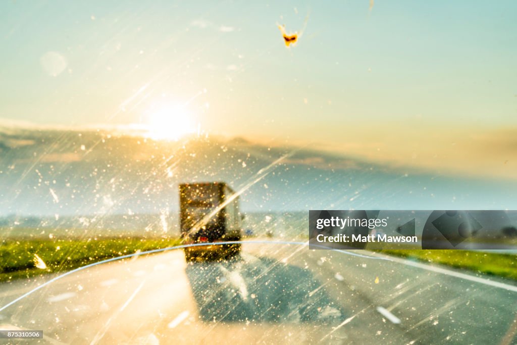 Driving on a road trip through Africa with a windscreen smeared with insects