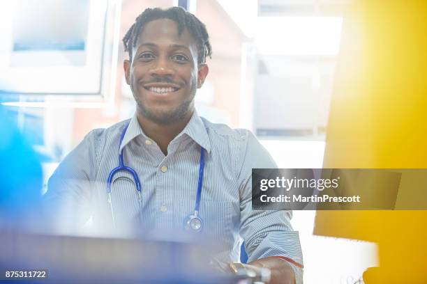 junior doctor smiling to camera - junior doctor stock pictures, royalty-free photos & images