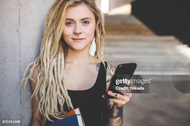 young tattooed women texting message on mobile phone - alternative lifestyle imagens e fotografias de stock