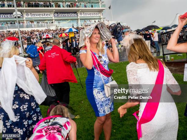 Hen party cope with a downpour on race day at Epsom. Ladies' Day is traditionally held on the first Friday of June, a multitude of ladies and gents...