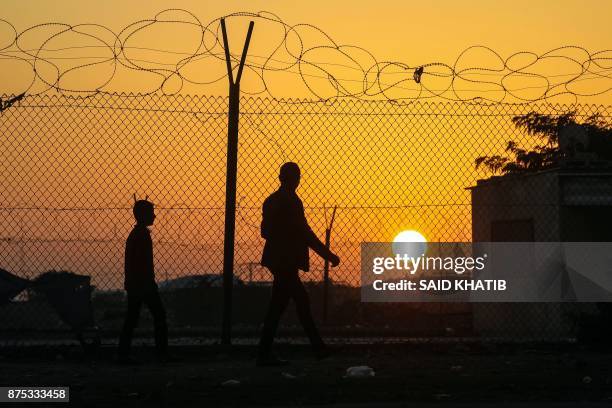 Palestinian walks behind a barbed wire fence near the closed gate of the Rafah border crossing bordering with Egypt, which is under the control of...