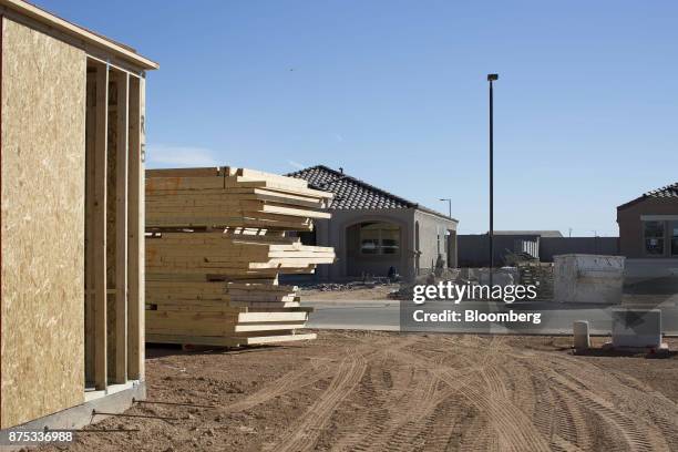 Wood sits stacked outside of homes under construction at the D.R. Horton Express Homes Magma Ranch housing development in Florence, Arizona, U.S., on...