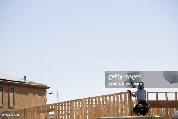 Contractor hammers the frame of a home under construction at the D.R. Horton Express Homes Magma Ranch housing development in Florence, Arizona,...