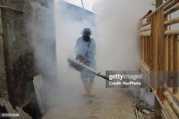 Health worker fumigation densely populated areas to prevent the spread of Aedes aegypti, in an attempt to control dengue fever at a neighborhood in...