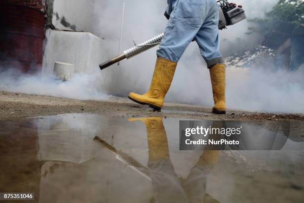 Health worker fumigation densely populated areas to prevent the spread of Aedes aegypti, in an attempt to control dengue fever at a neighborhood in...