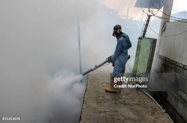 Health worker fumigation densely populated areas to prevent the spread of Aedes aegypti, in an attempt to control dengue fever at a neighborhood in...