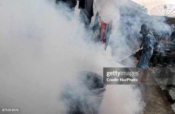 Health worker fumigation densely populated areas to prevent the spread of Aedes aegypti, in an attempt to control dengue fever at a neighborhood in...