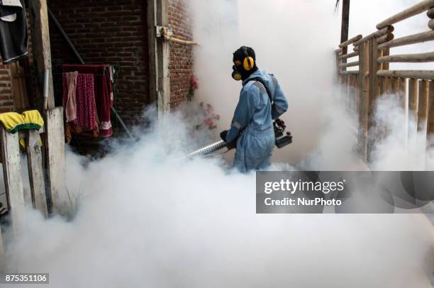 Health worker fumigation densely populated areas to prevent the spread of Aedes aegypti, in an attempt to control dengue fever at a neighborhood in...