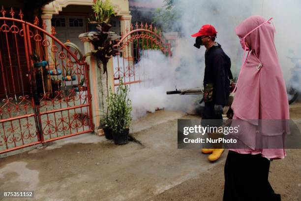 Health worker fumigation densely populated areas to prevent the spread of Aedes aegypti, in an attempt to control dengue fever at a neighborhood in...