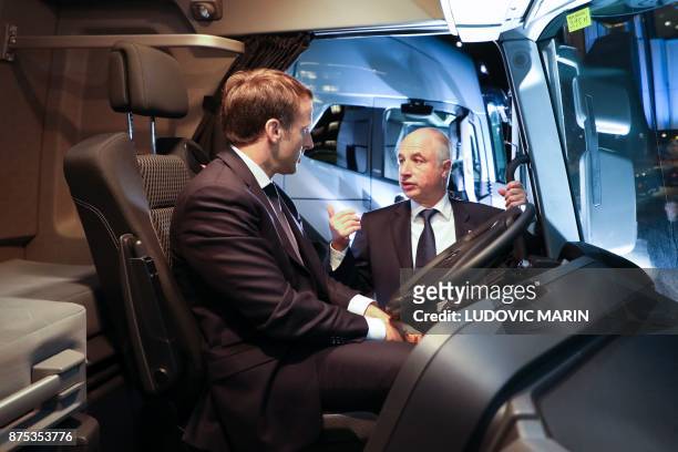 France's President Emmanuel Macron speaks with a Volvo employee inside of a Renault truck during a visit to the Volvo Campus Lundby of the Swedish...