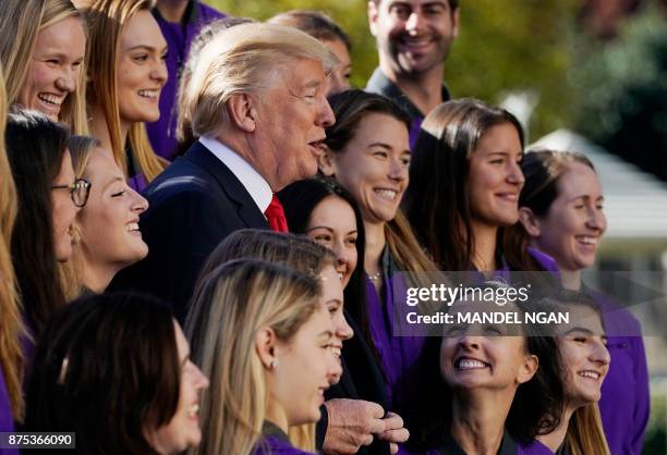 President Donald Trump poses with members of the University of Washington women's rowing team on the South Lawn of the White House during an event...