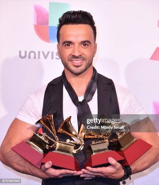 Luis Fonsi poses with awards for Best Urban Fusion/Performance, Best Short Form Music Video, Song of the Year and Record of the Year in the press...