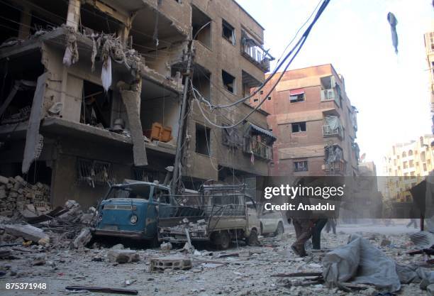 Men are seen among collapsed buildings after Assad regime's warcrafts carry out intensifying airstrikes over residential areas of Arbin town of the...