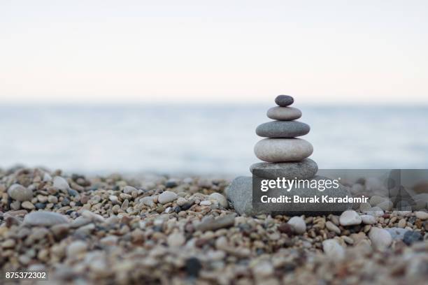 balanced stones on a pebble beach - medicina alternativa foto e immagini stock