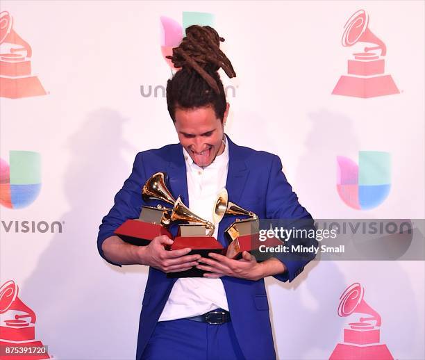 Vicente Garcia poses with awards for Best New Artist, Best Tropical Song and Best Singer-Songwriter Album in the press room during The 18th Annual...