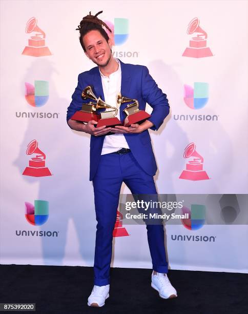 Vicente Garcia poses with awards for Best New Artist, Best Tropical Song and Best Singer-Songwriter Album in the press room during The 18th Annual...