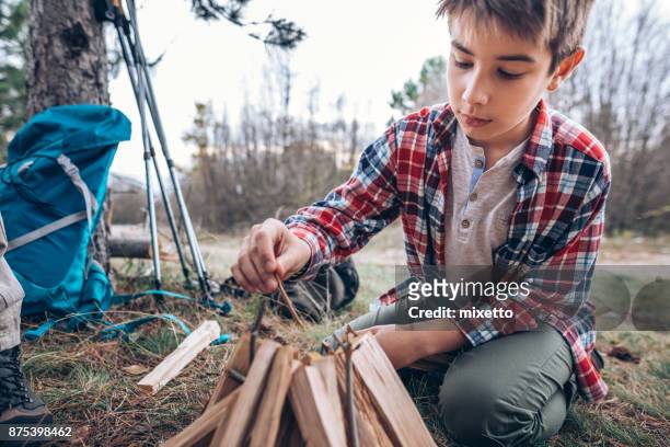 boy making campfire - fall camping stock pictures, royalty-free photos & images