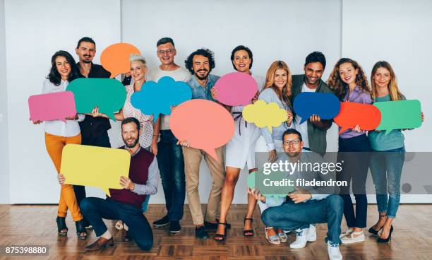 businesspeople holding speech bubbles - holding speech bubble stock pictures, royalty-free photos & images