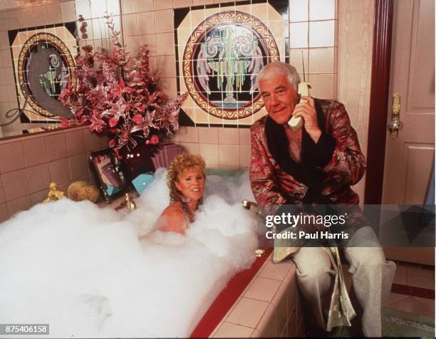 Marvin Mitchelson on the phone and his wife, Marcella in the bath, pose in their palatial home on January 1, 1989 in West Hollywood, California,