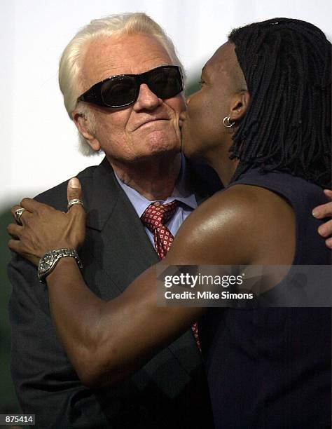 The Reverend Billy Graham receives a kiss from Christian rock star Michael Tate of the band dcTalk June 29, 2002 in Cincinnati, Ohio. Graham was...