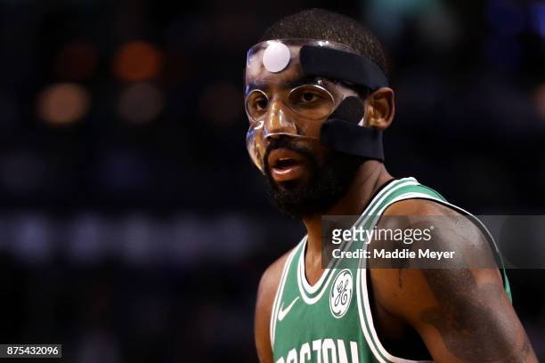 Kyrie Irving of the Boston Celtics, wearing a mask due to a facial fracture, looks on during the first quarter against the Golden State Warriors at...