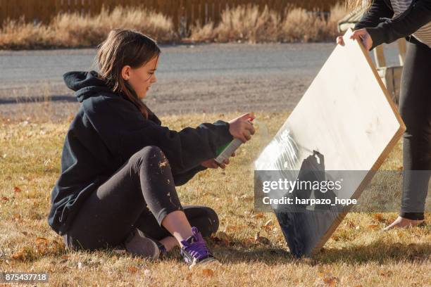 teenage girl spray painting. - harpazo hope stock pictures, royalty-free photos & images