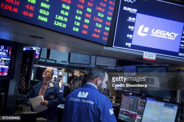 Traders work on the floor of the New York Stock Exchange in New York, U.S., on Friday, Nov. 17, 2017. U.S. Stocks edged lower after the best rally in...