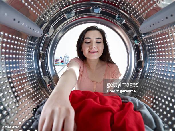 hausfrau die wäsche aus der maschine herausnehmen - remove clothes from stock-fotos und bilder